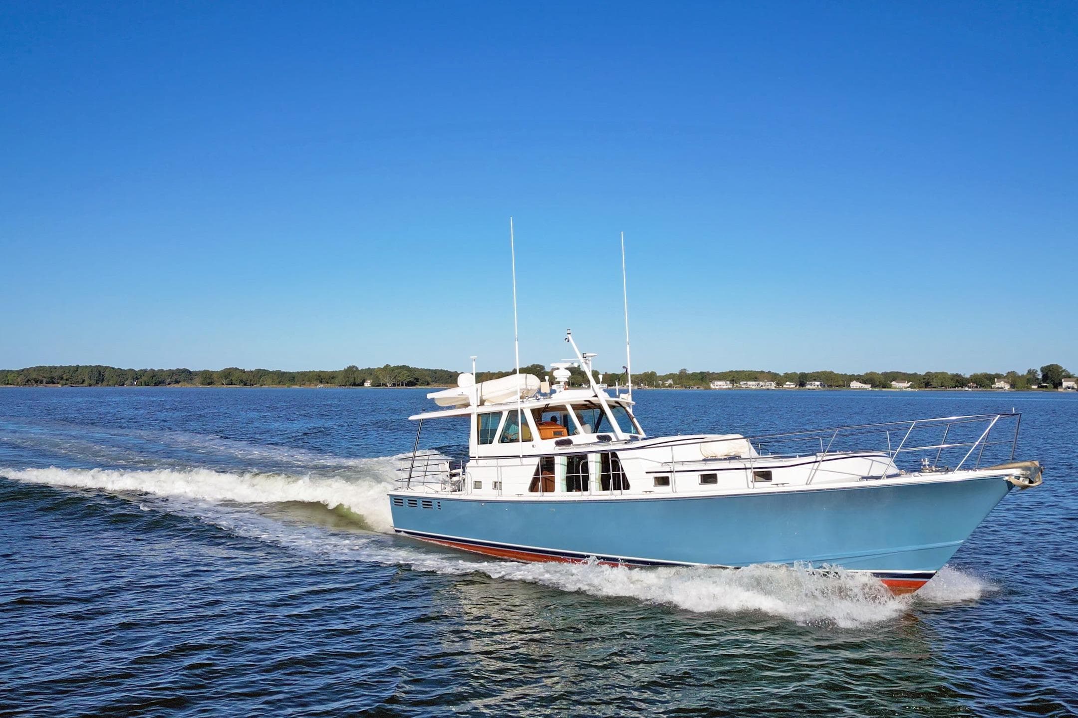 2001 Dettling 51 yacht cruising on a clear blue lake under a sunny sky.