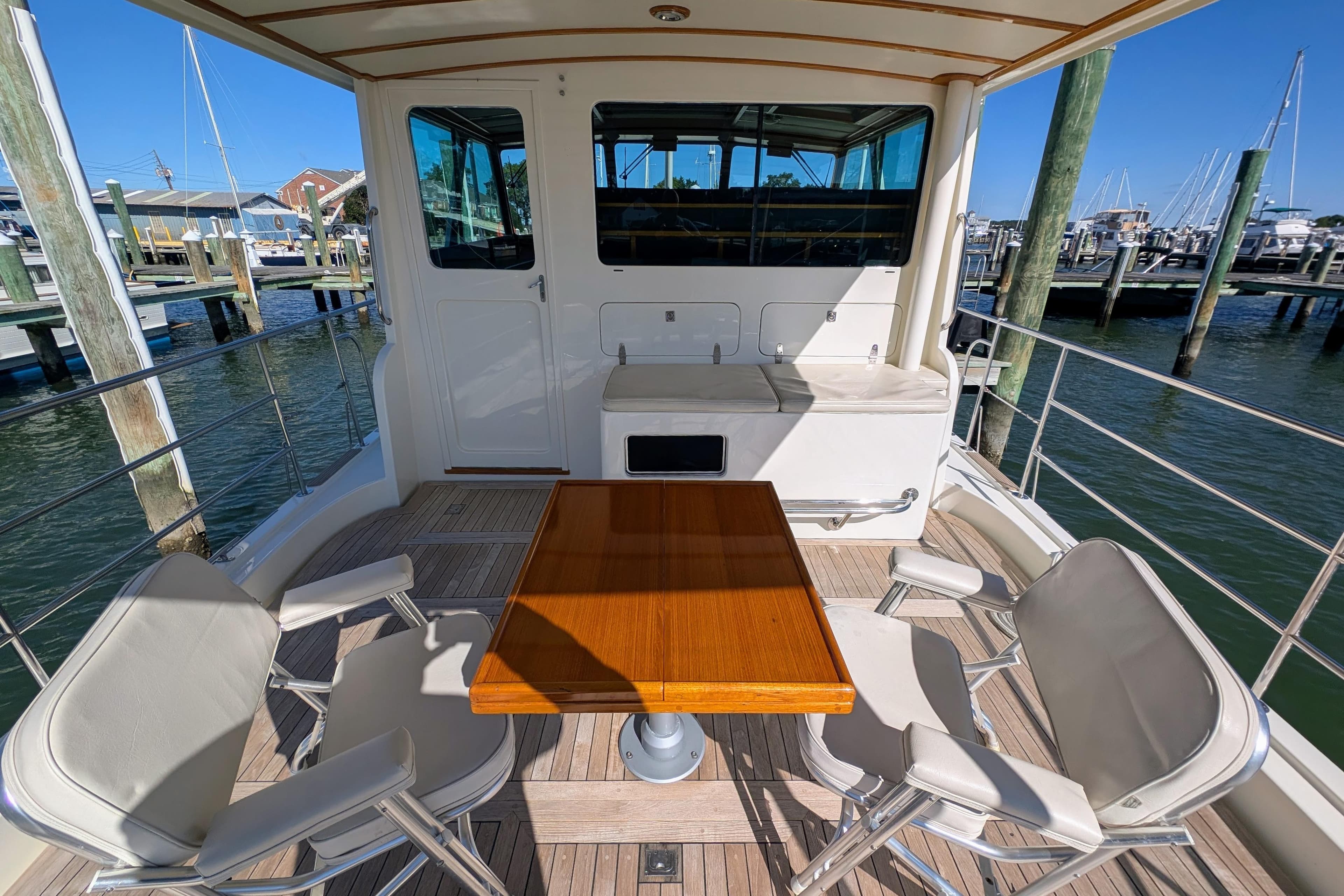 2001 Dettling 51 yacht deck with table and chairs, docked at marina.