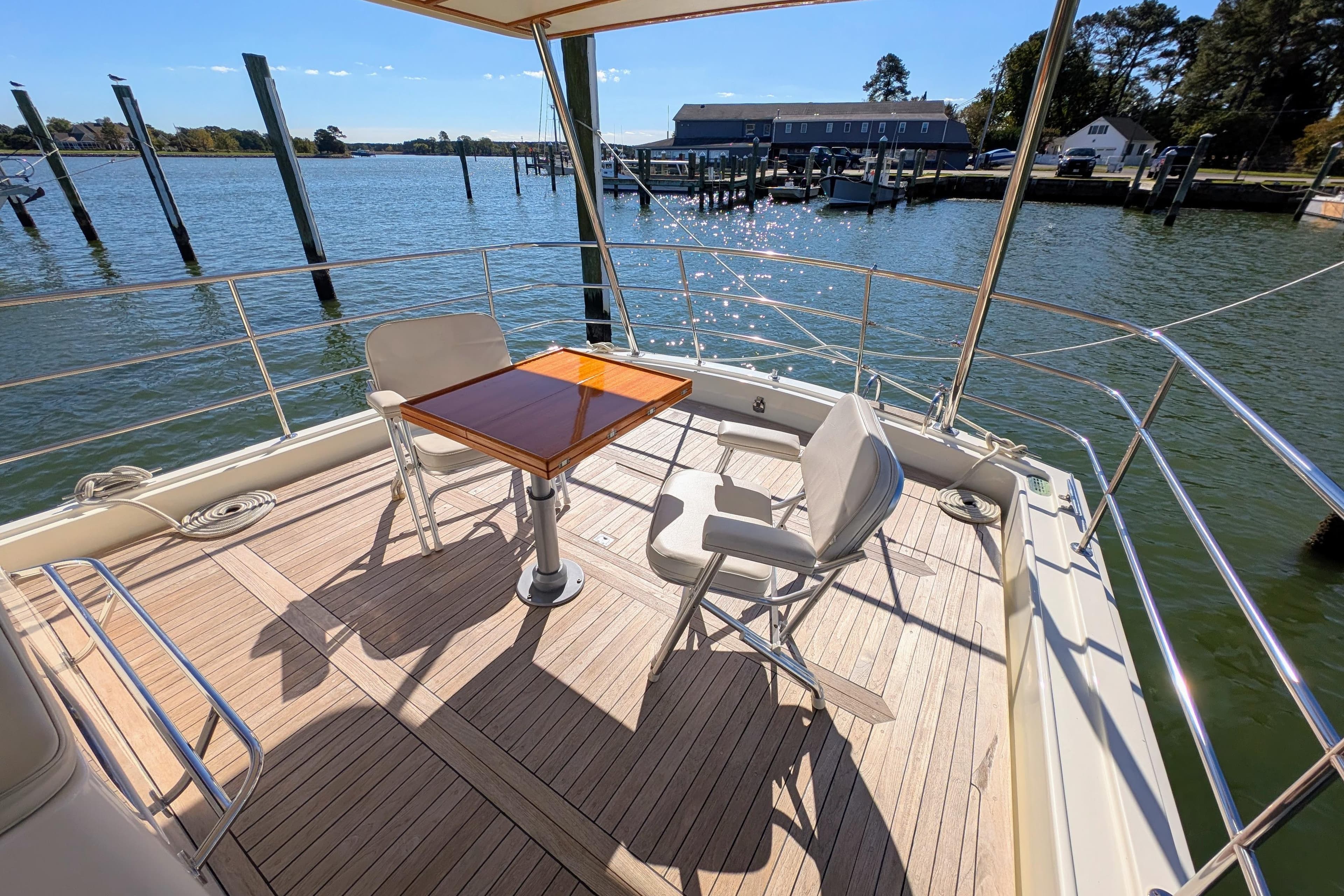 Luxury Dettling 51 yacht deck with chairs and table, overlooking serene waterfront, 2001 model.