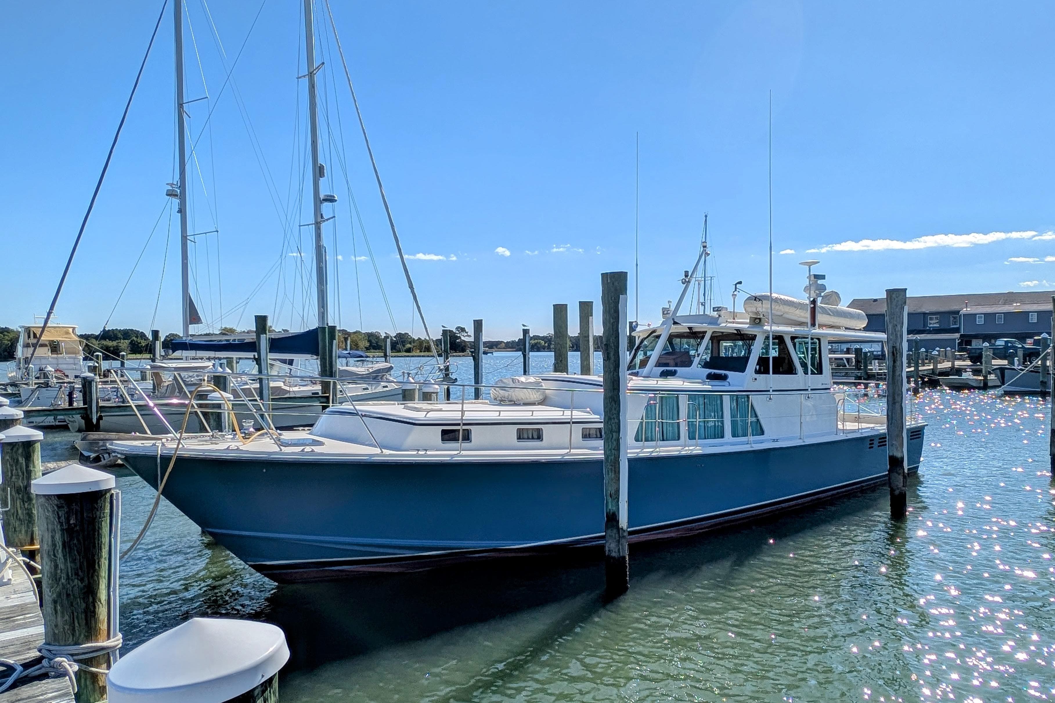 2001 Dettling 51 yacht docked at marina under clear blue sky.