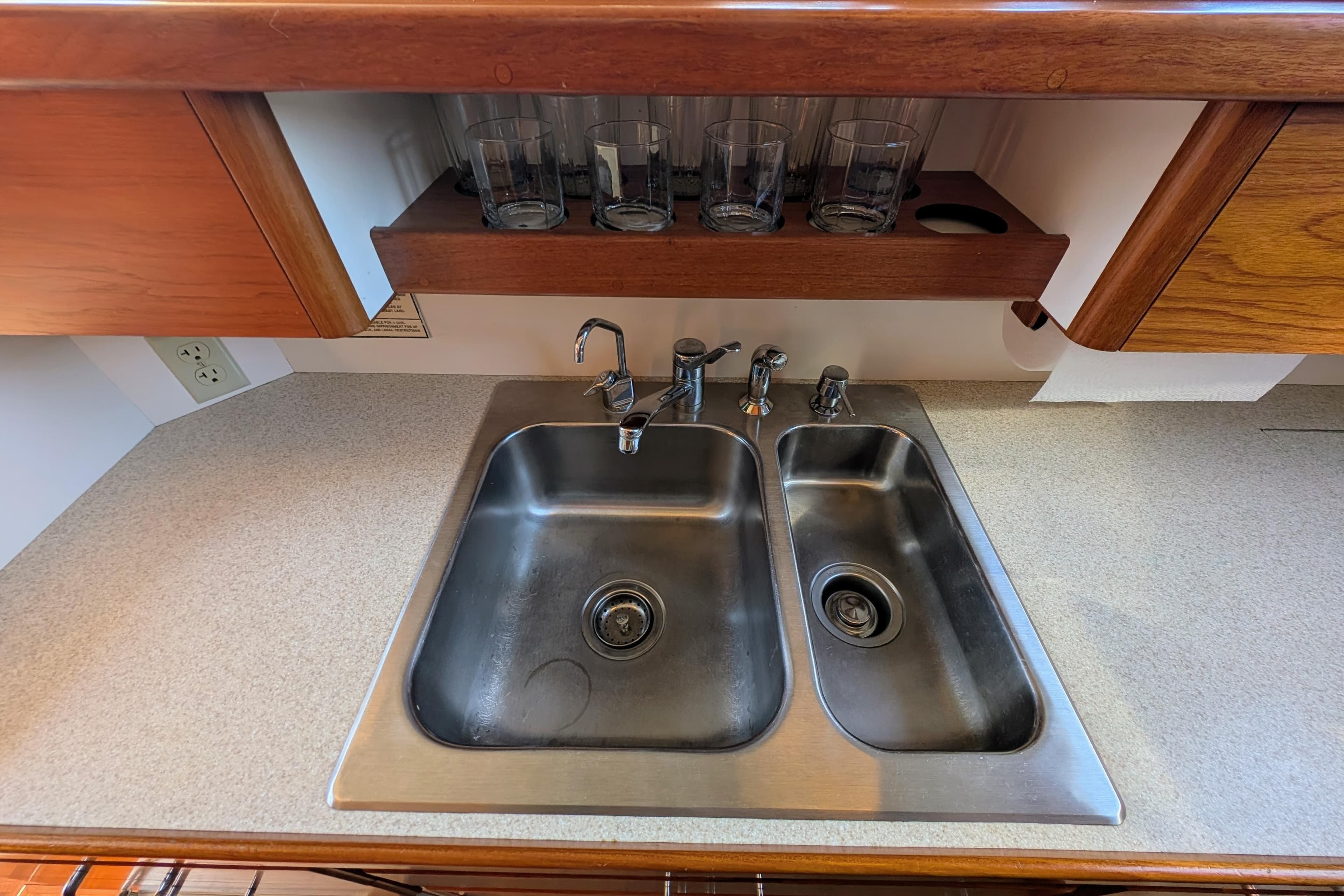 Double stainless steel sink in a Dettling 51 yacht kitchen, 2001 model, with wooden cabinetry.