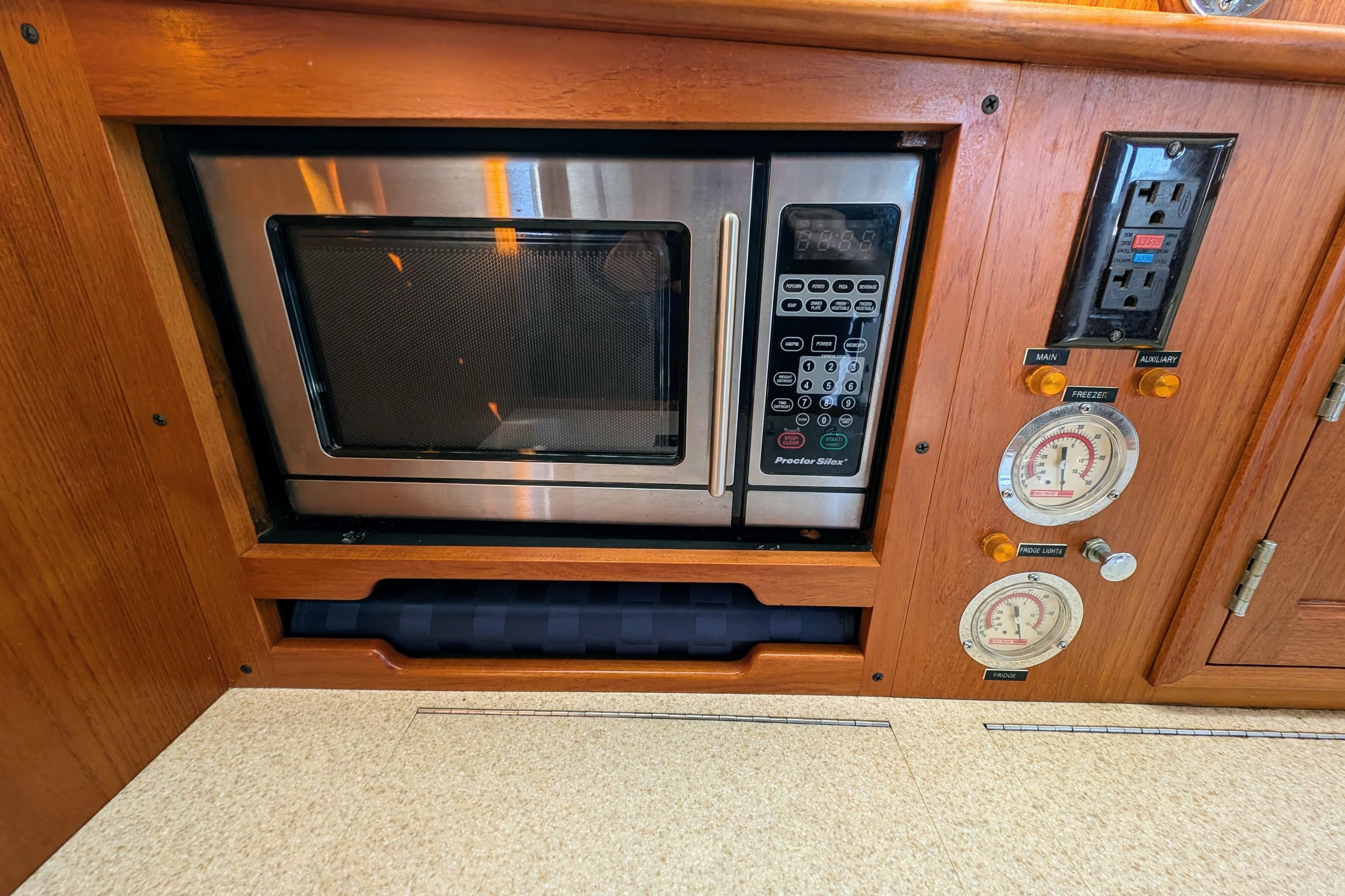 Built-in microwave and control panel in a 2001 Dettling 51 yacht kitchen.