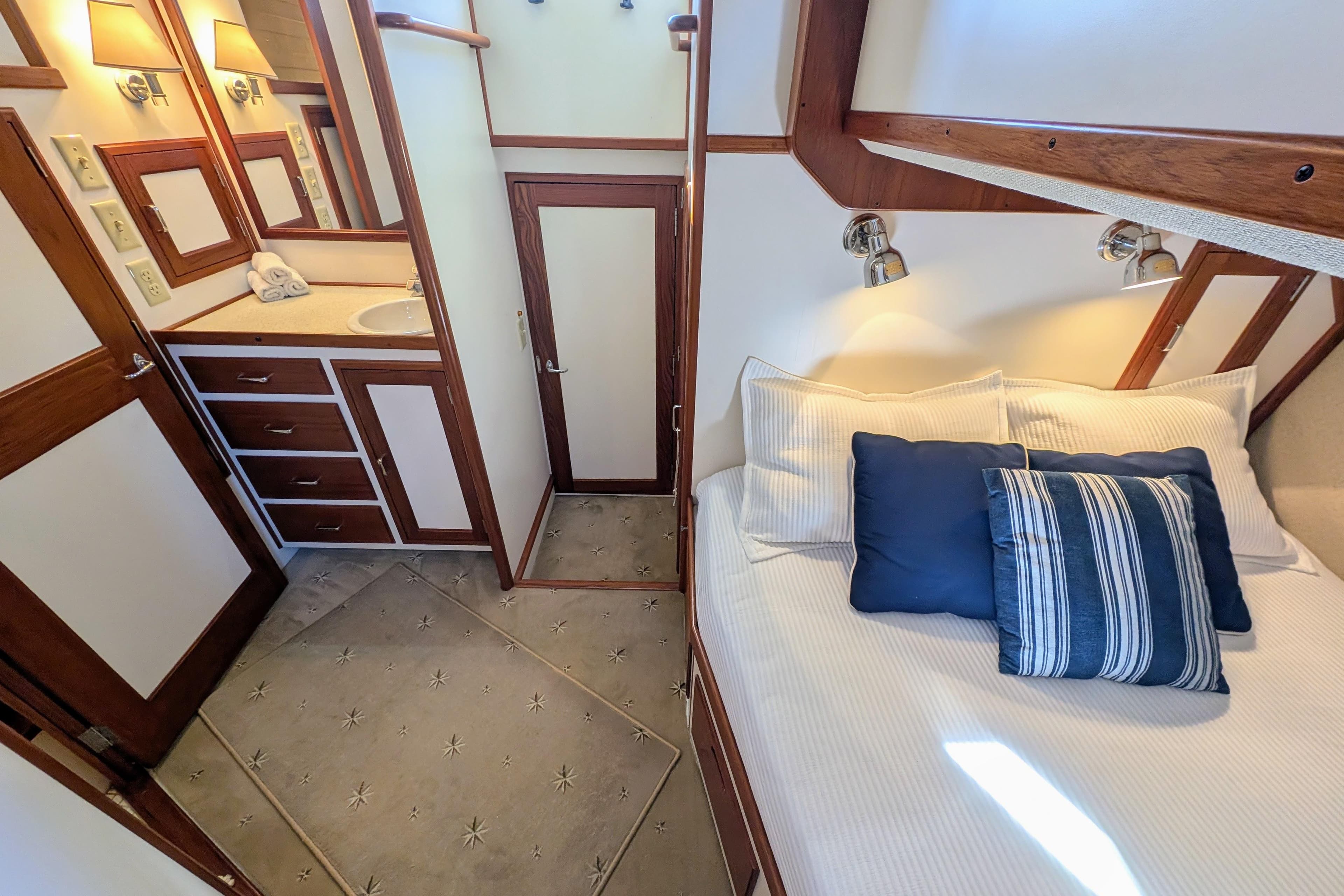 Luxurious 2001 Dettling 51 yacht interior with cozy bed and elegant bathroom.