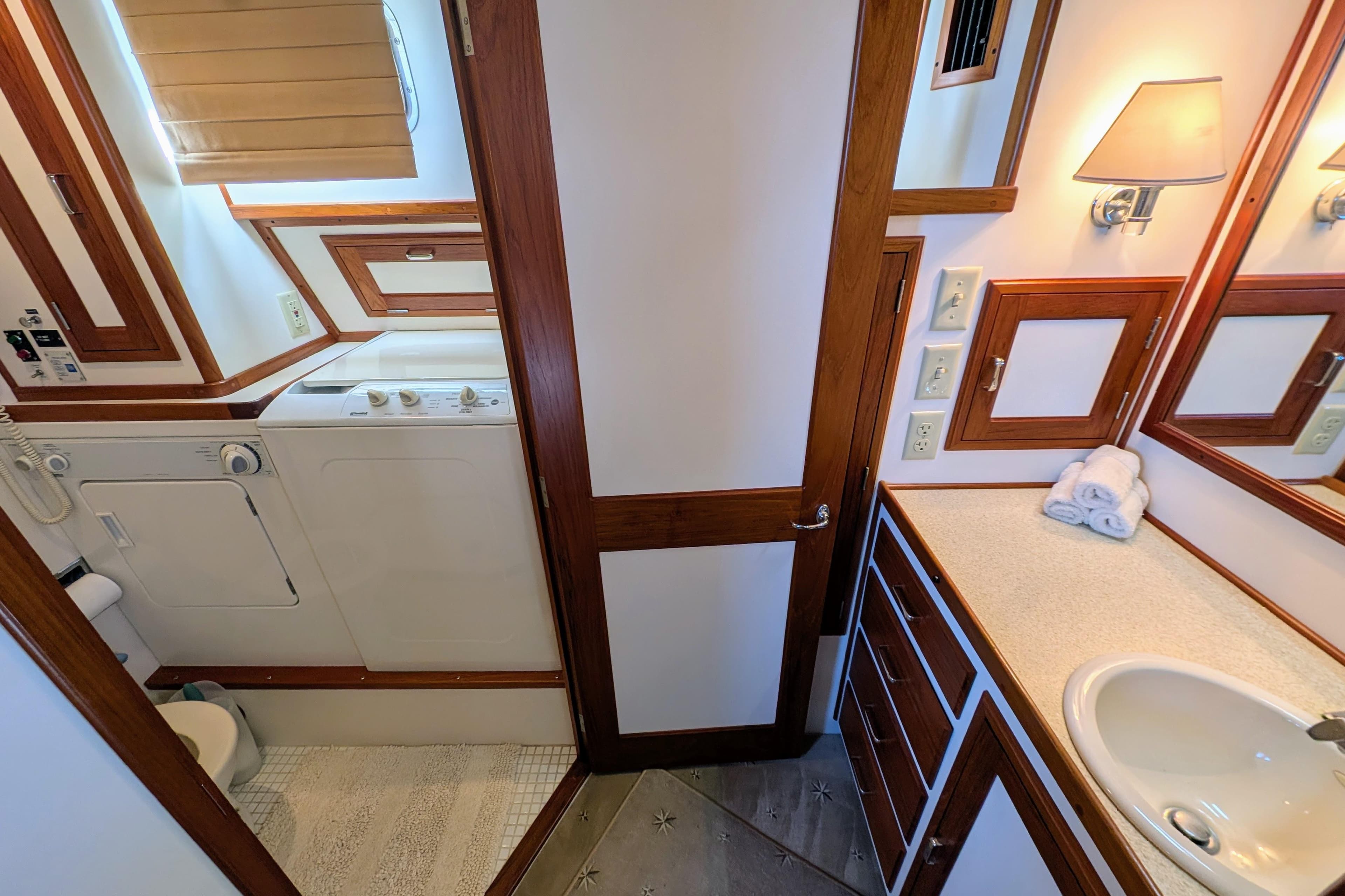 Laundry and bathroom area in a 2001 Dettling 51 yacht, featuring wood accents and modern amenities.