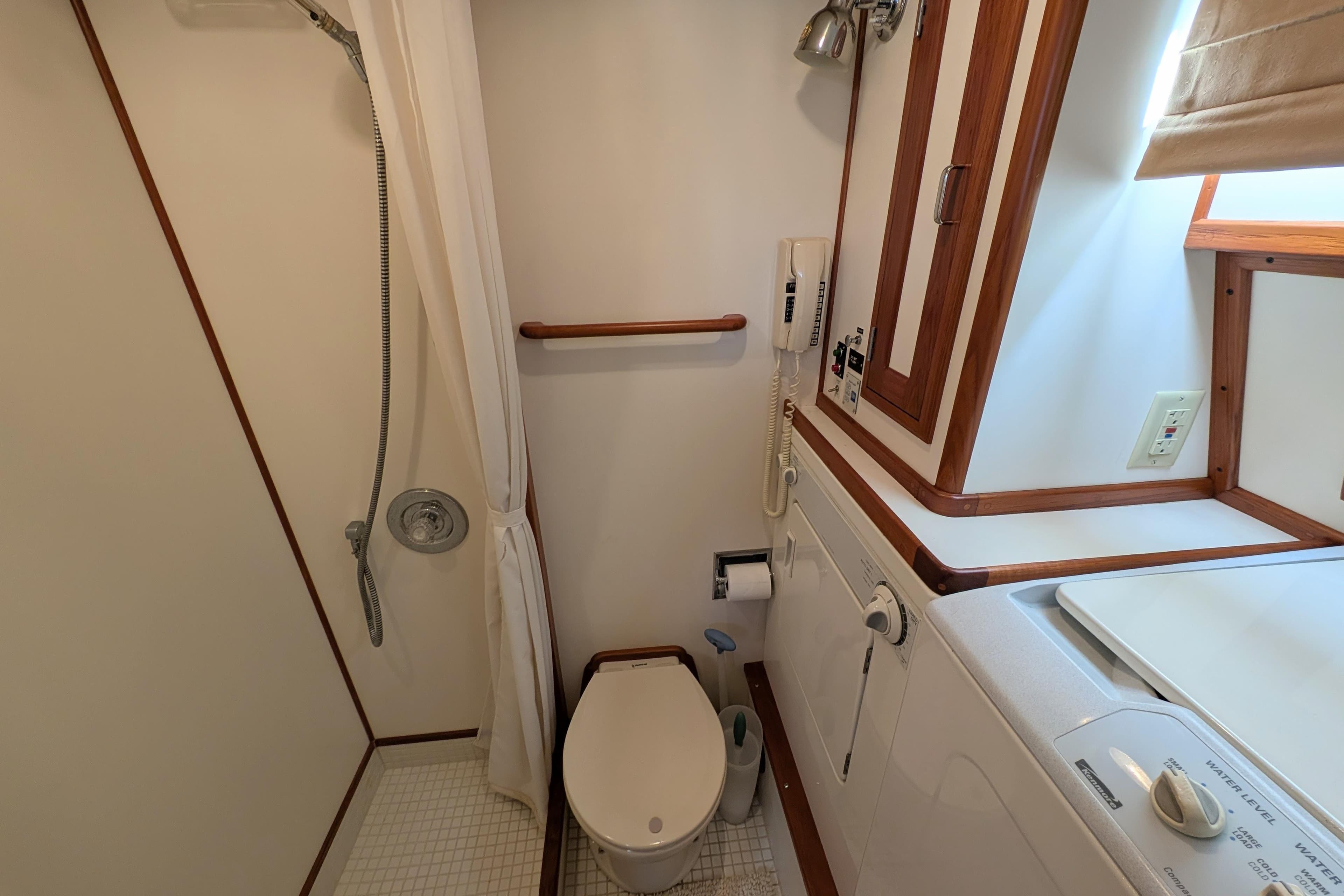 Bathroom in 2001 Dettling 51 yacht with shower, toilet, and washing machine.