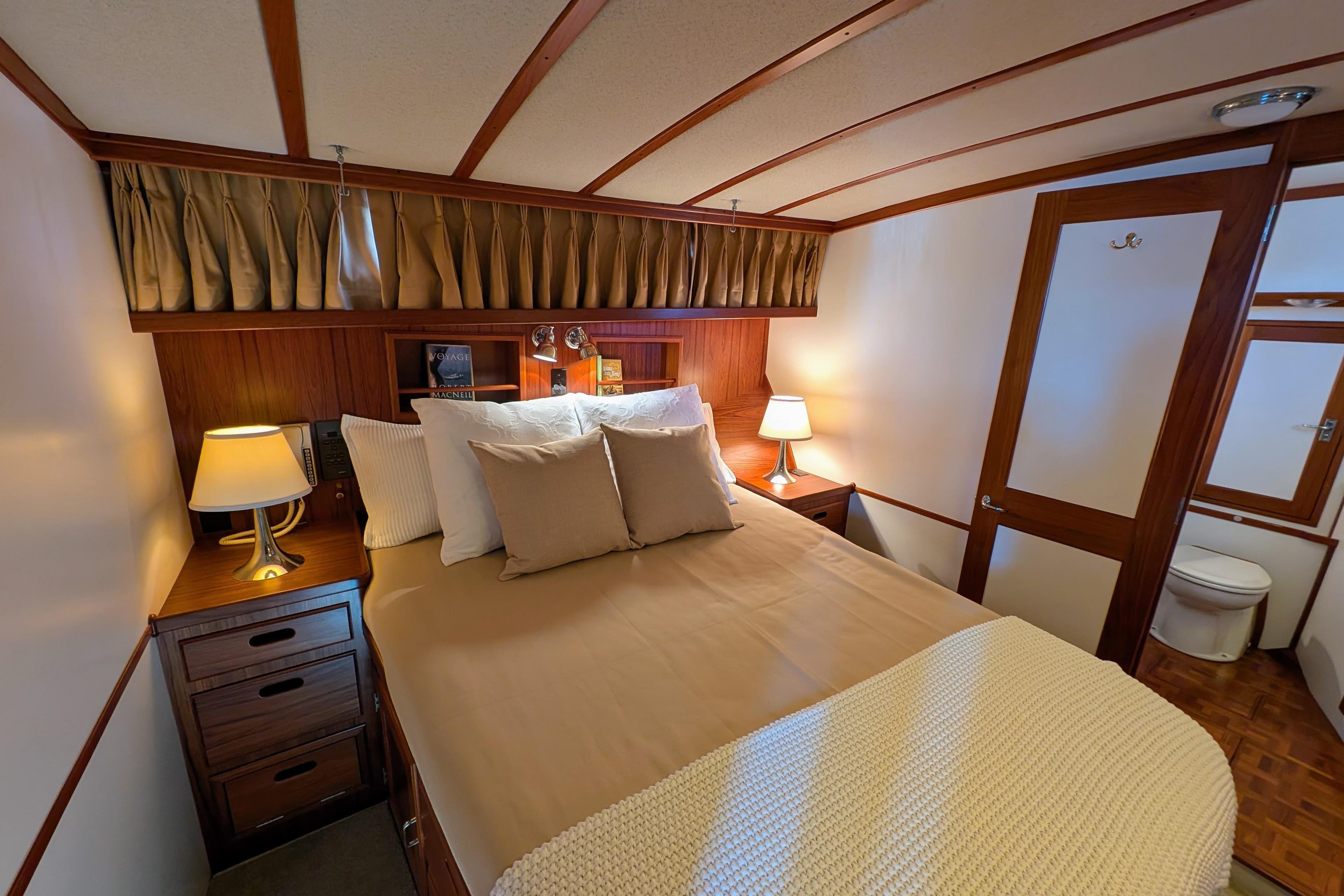 Luxurious cabin interior of 2001 Dettling 51 yacht with cozy bed and elegant decor.