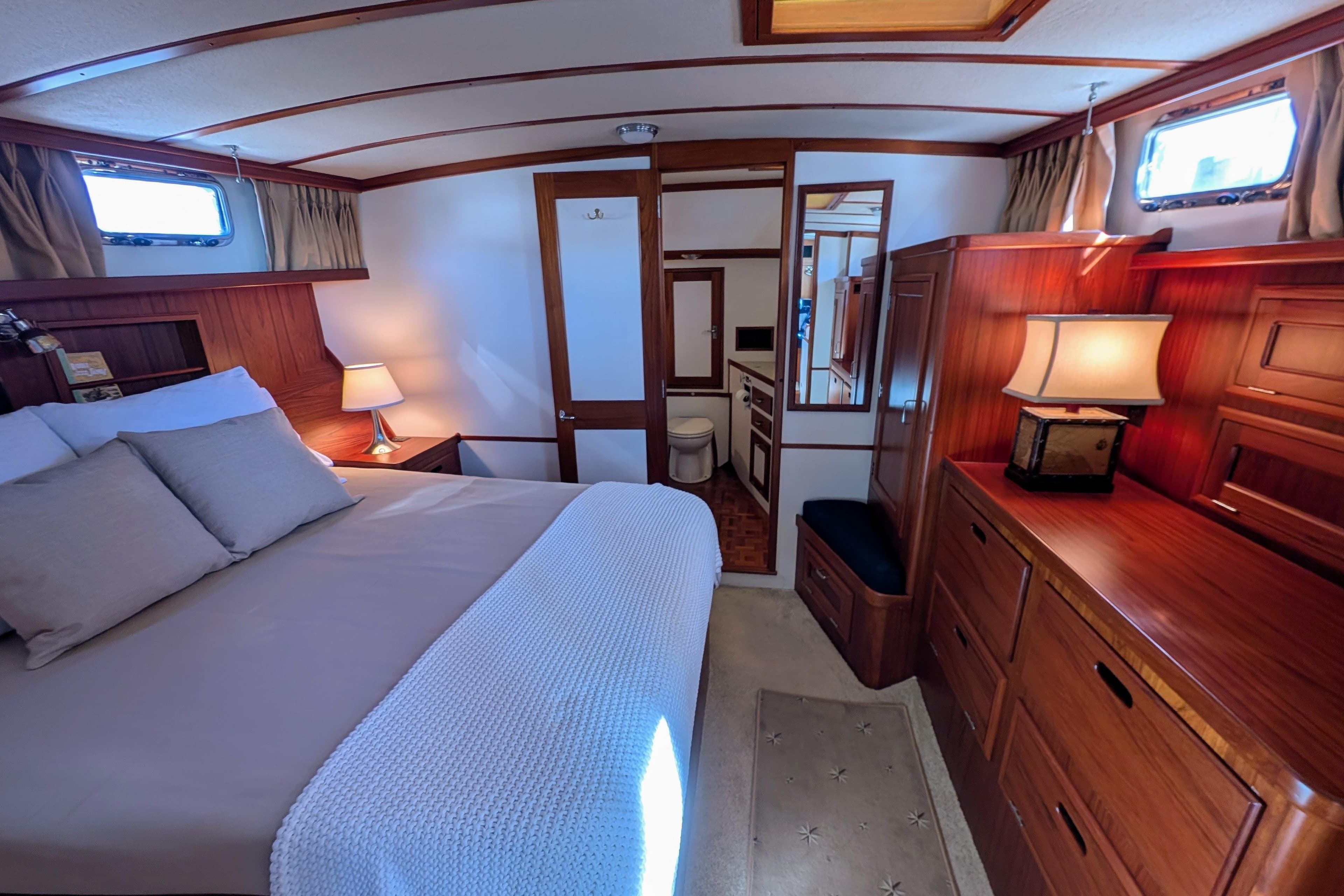 Luxurious cabin interior of 2001 Dettling 51 yacht with elegant wood furnishings.