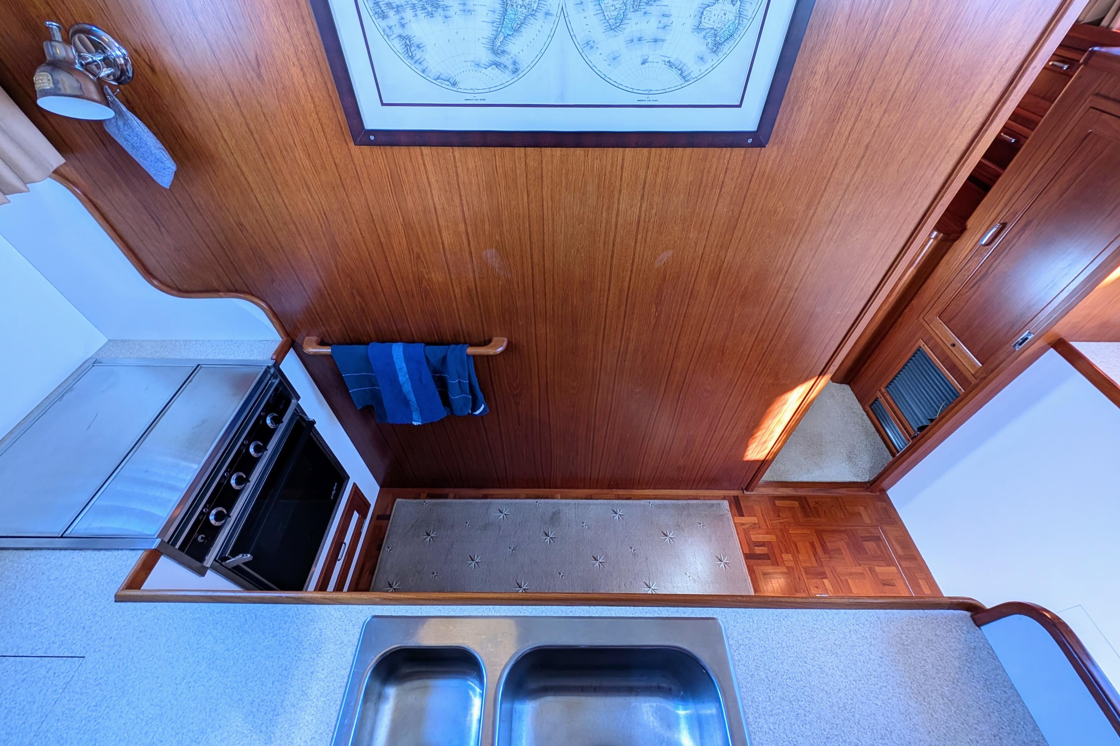 Interior of 2001 Dettling 51 yacht kitchen with wood paneling and stainless steel sink.