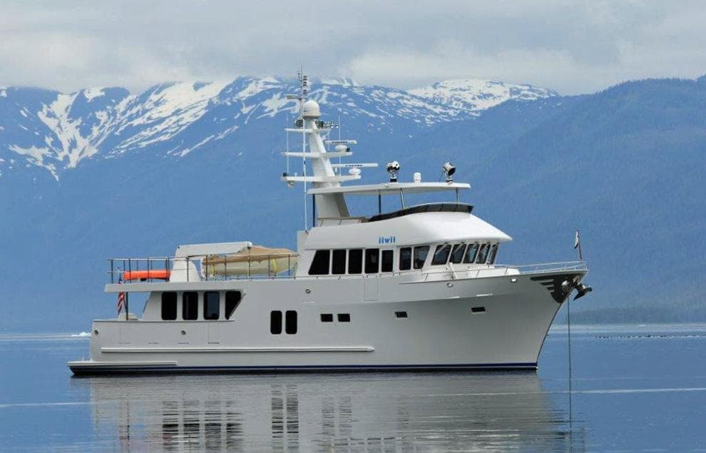 2017 Northern Marine Expedition yacht on calm water with snowy mountains in the background.