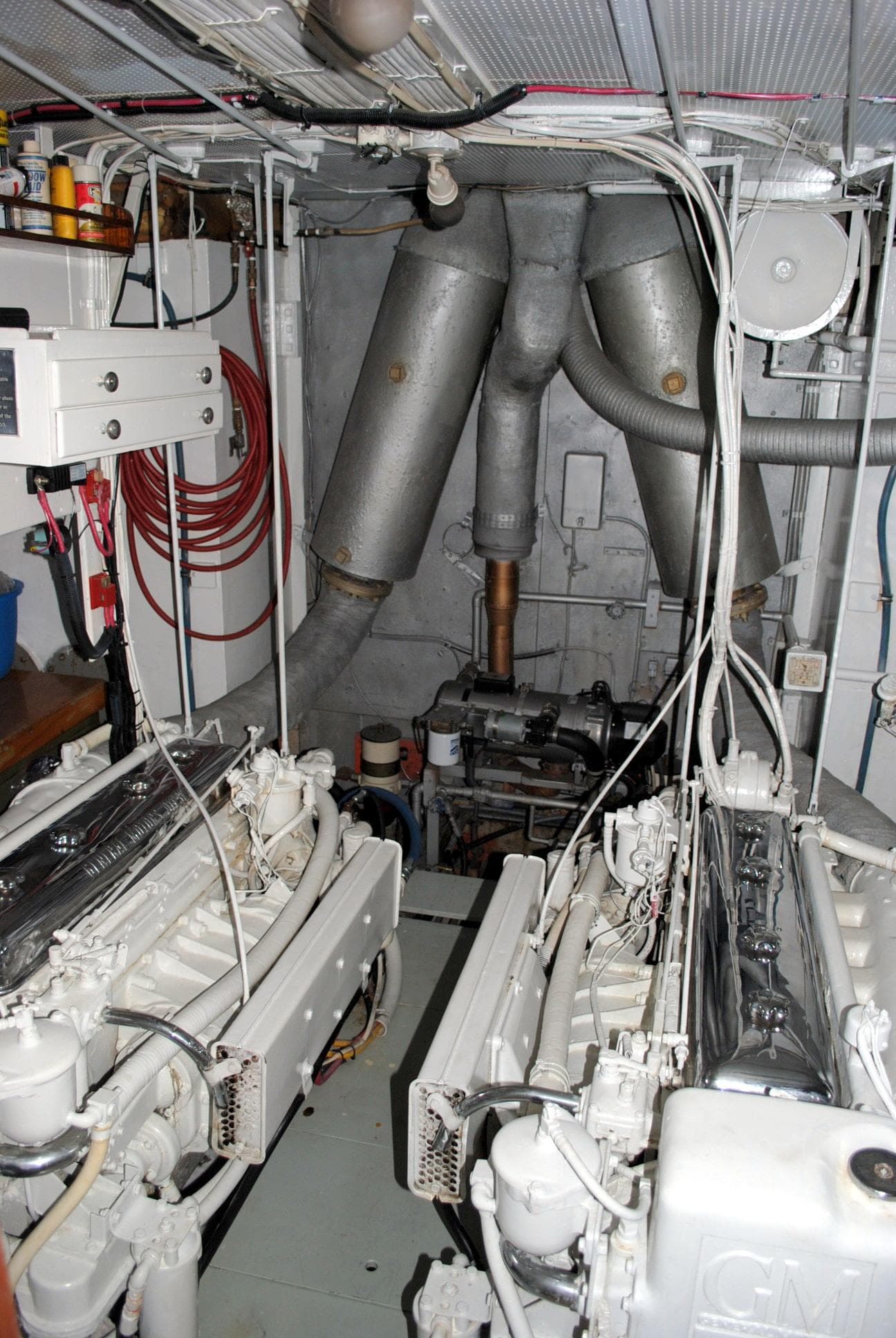 Engine room of a 1947 Trumpy "60" Houseboat with visible machinery and exhaust pipes.