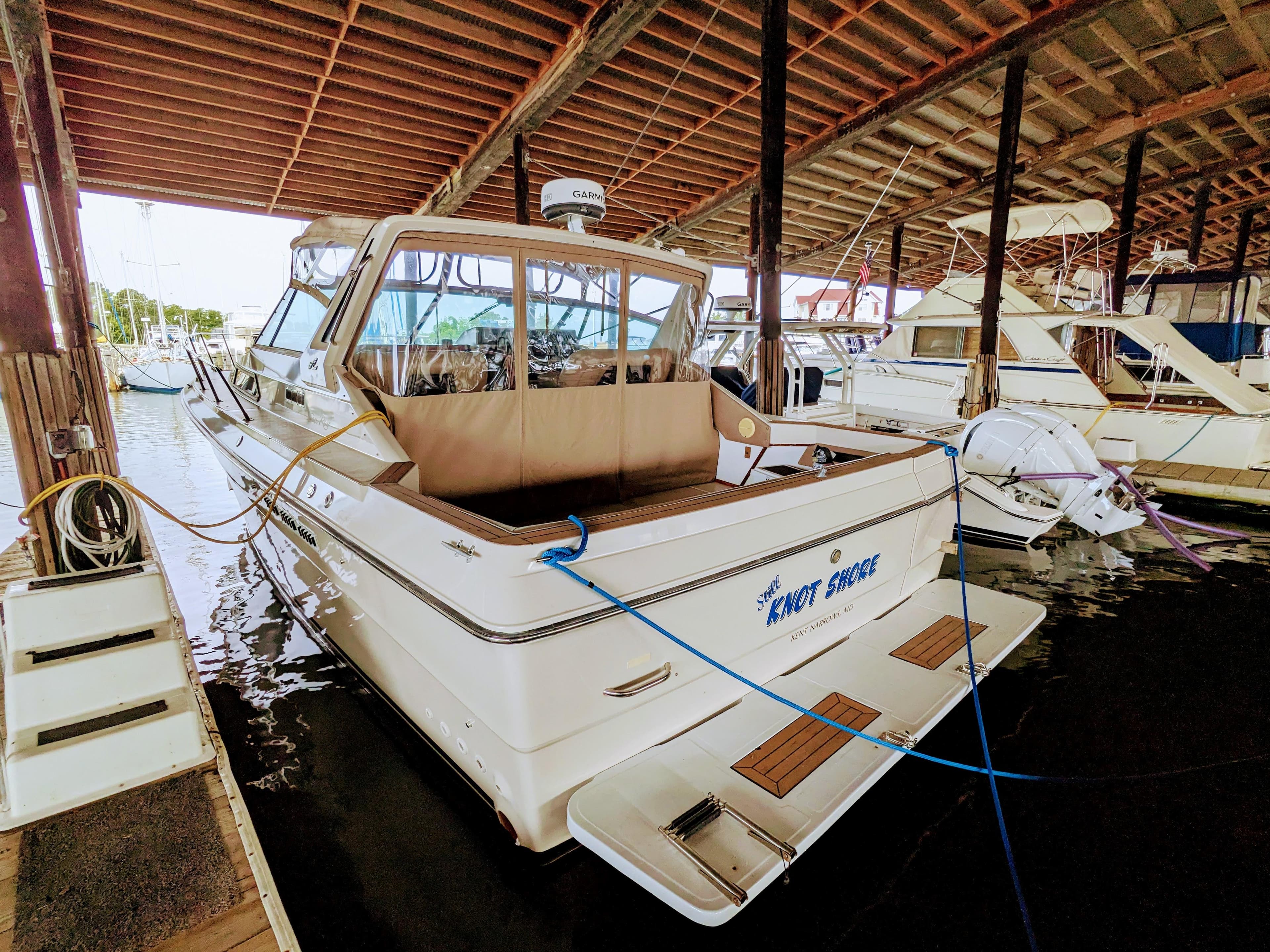 1988 Sea Ray 390 Express Cruiser docked in a covered marina.