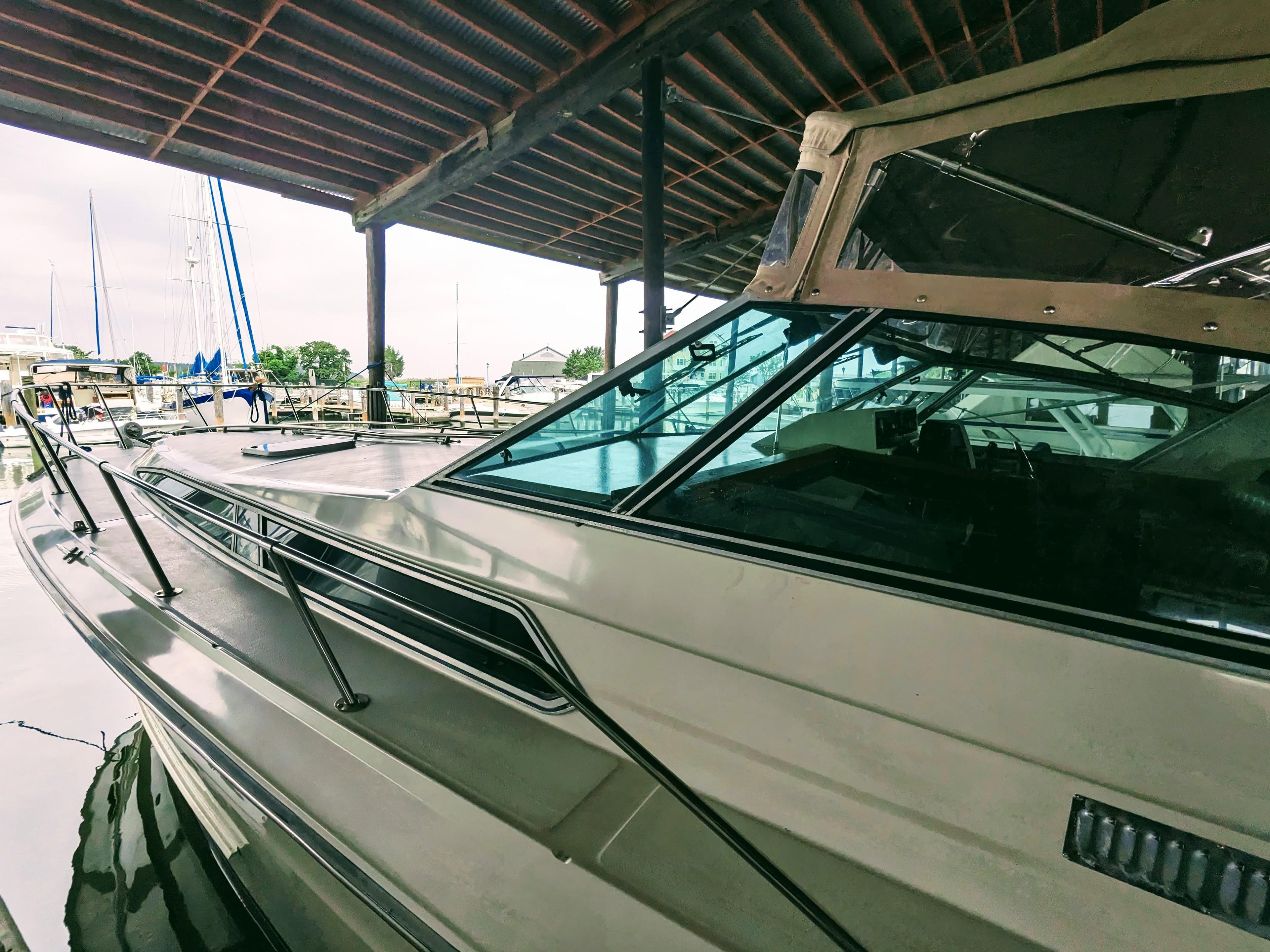 1988 Sea Ray 390 Express Cruiser docked under a covered marina.