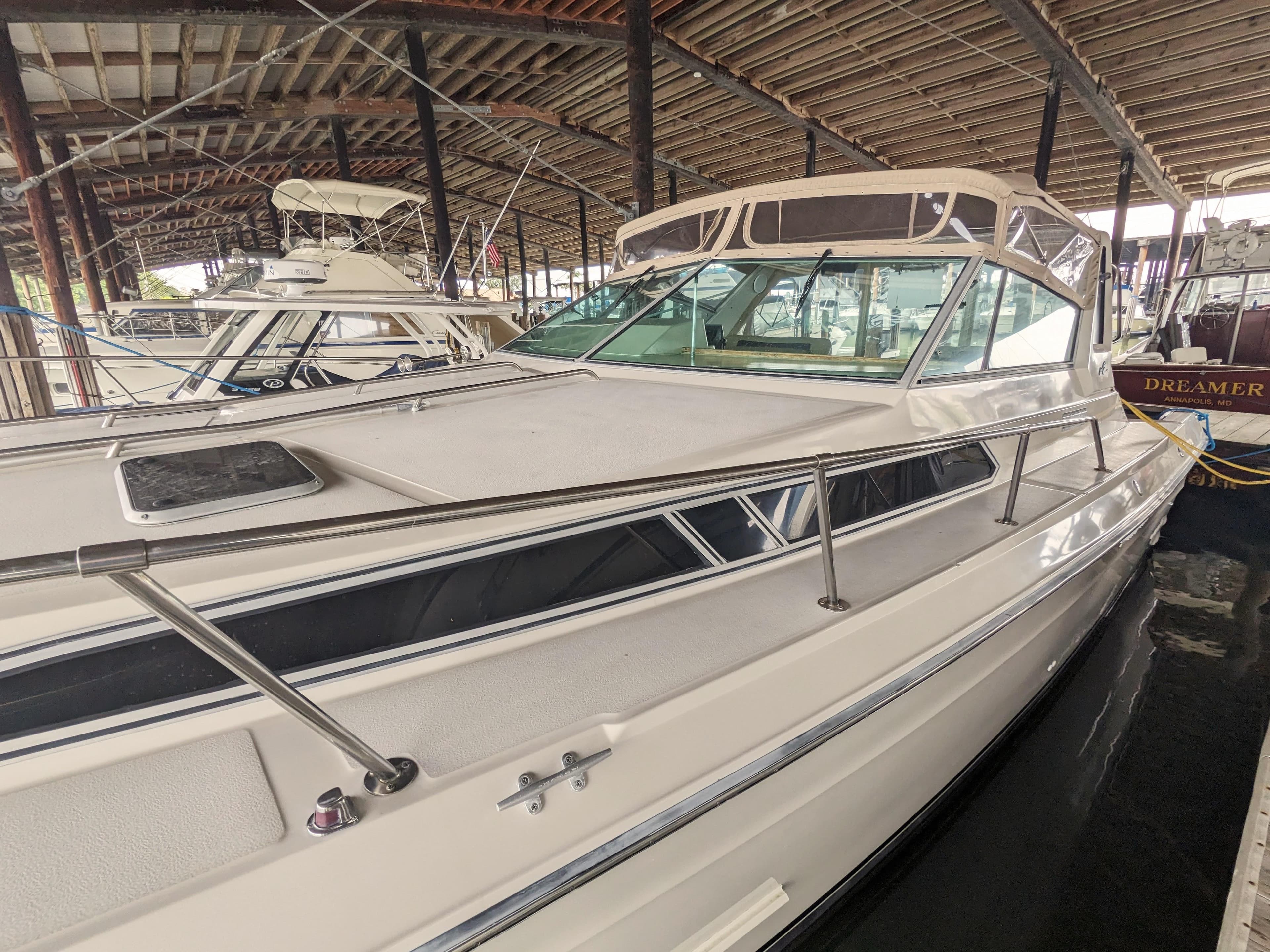 1988 Sea Ray 390 Express Cruiser docked in a covered marina, showcasing sleek design.