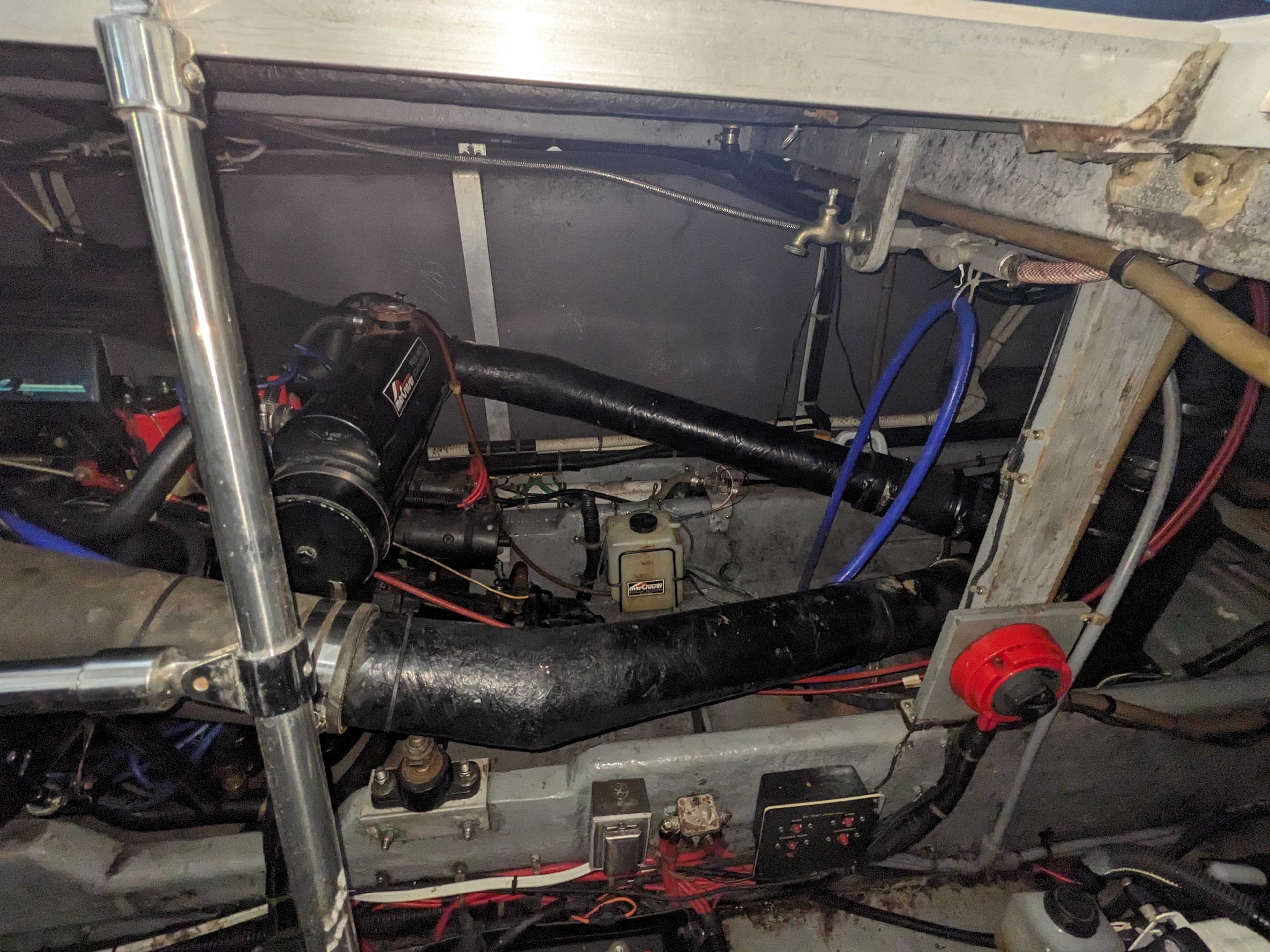 Engine compartment of a 1988 Sea Ray 390 Express Cruiser with visible hoses and wiring.