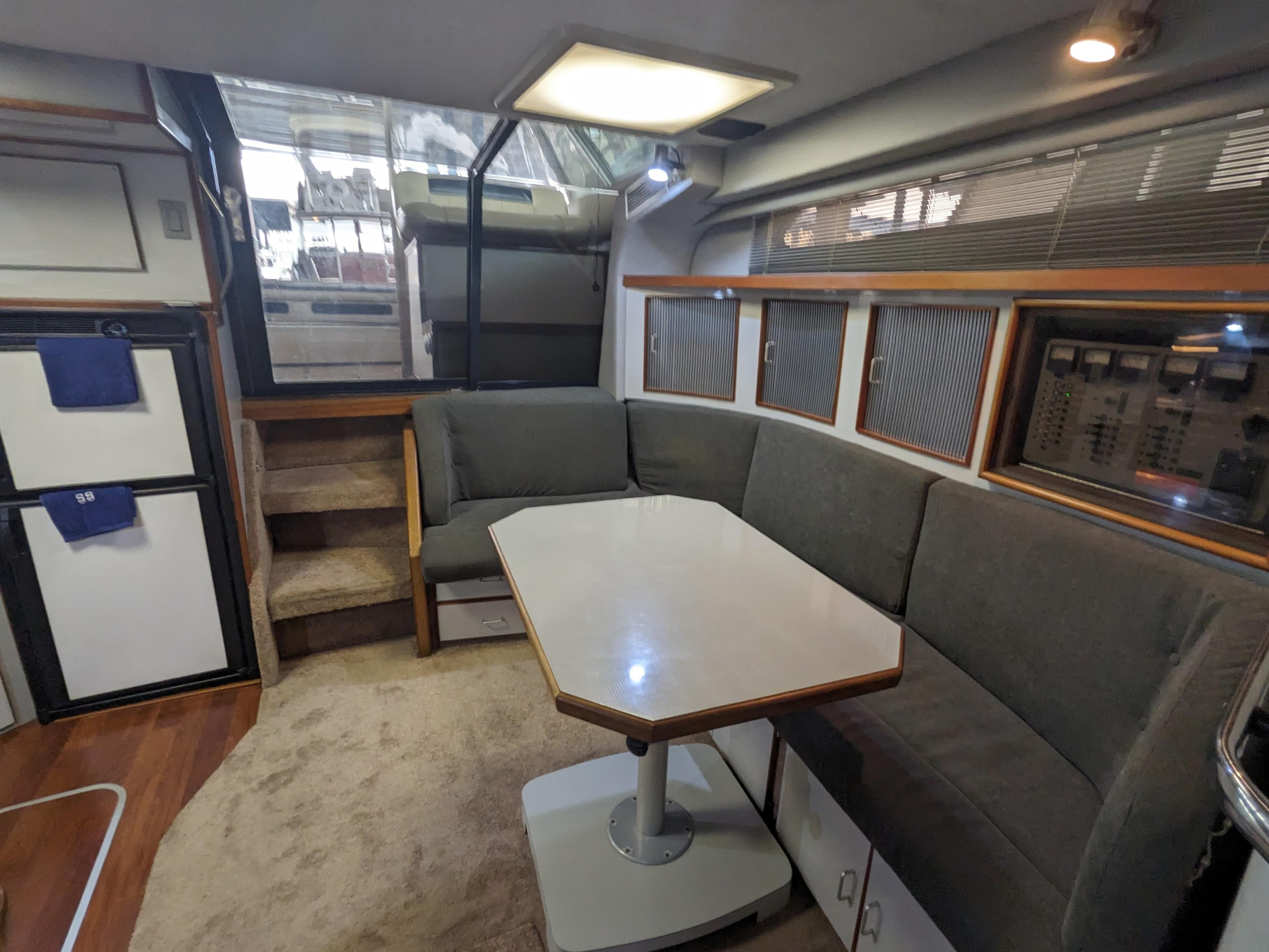 1988 Sea Ray 390 Express Cruiser interior with gray seating and dining table.
