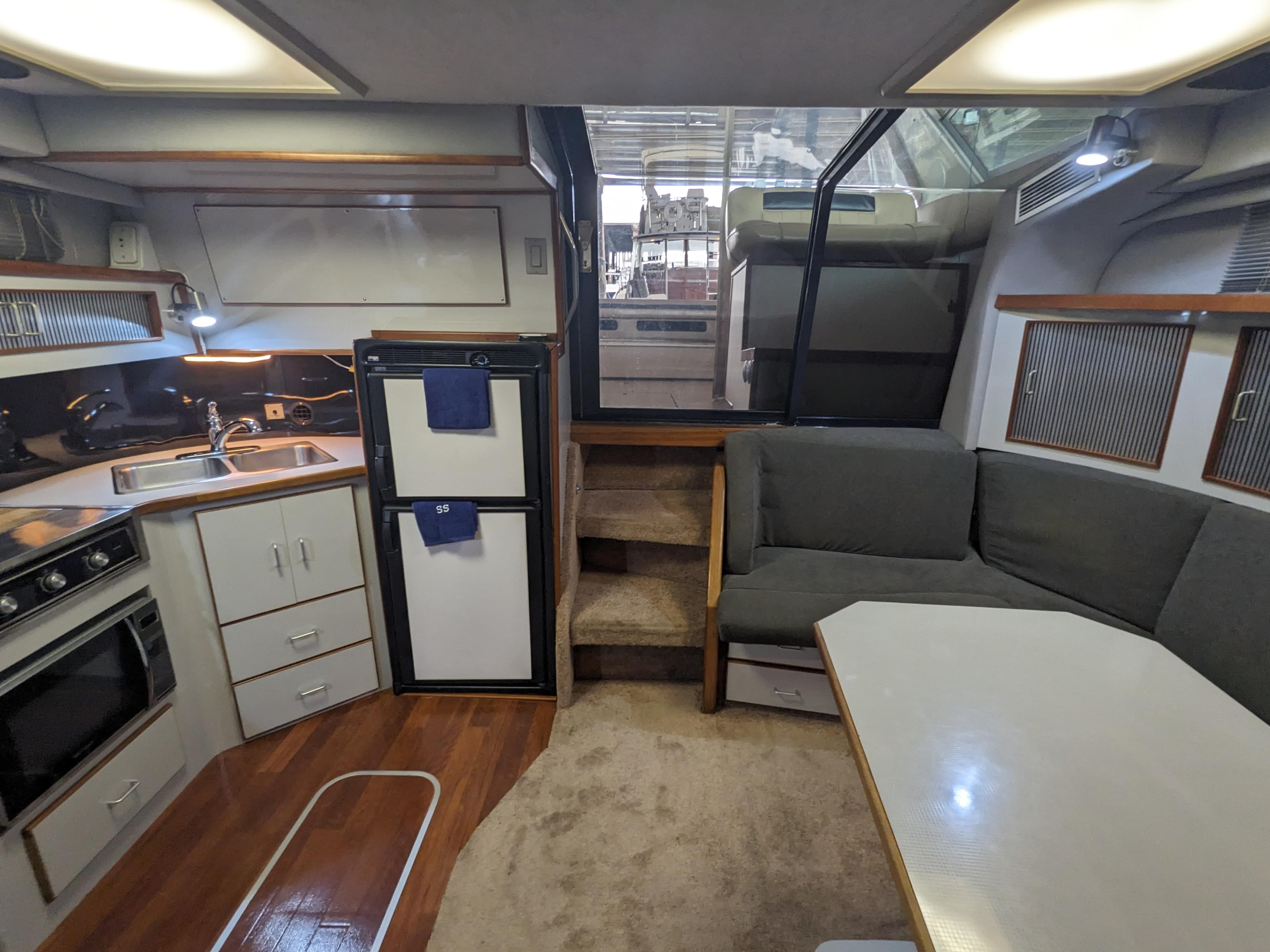 1988 Sea Ray 390 Express Cruiser interior with kitchen, seating, and stairs.