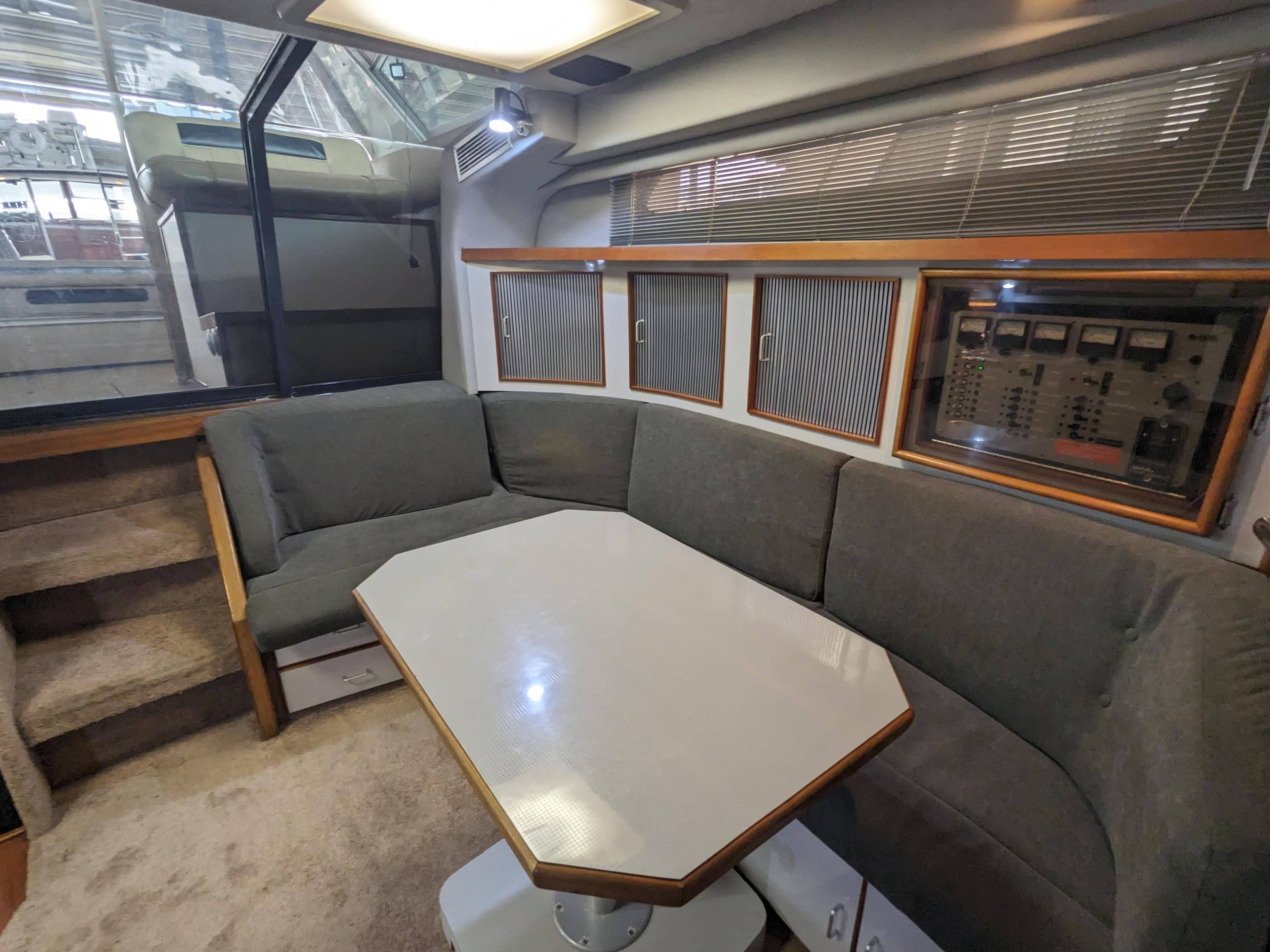 1988 Sea Ray 390 Express Cruiser interior with gray seating and a central table.