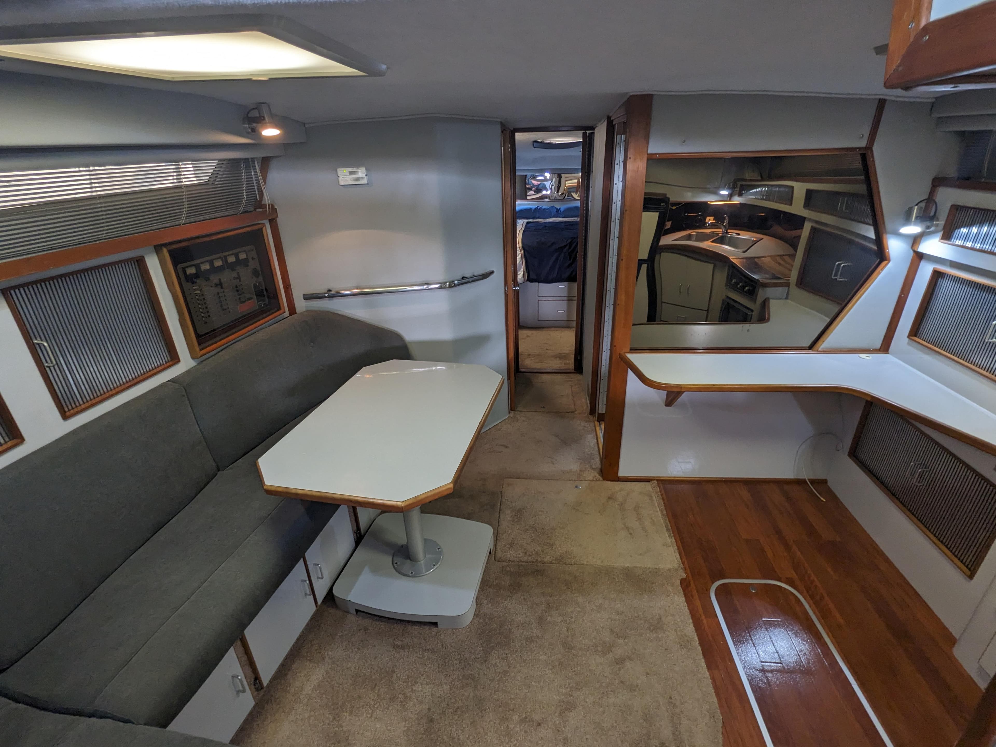 Interior of 1988 Sea Ray 390 Express Cruiser with seating, table, and kitchenette.