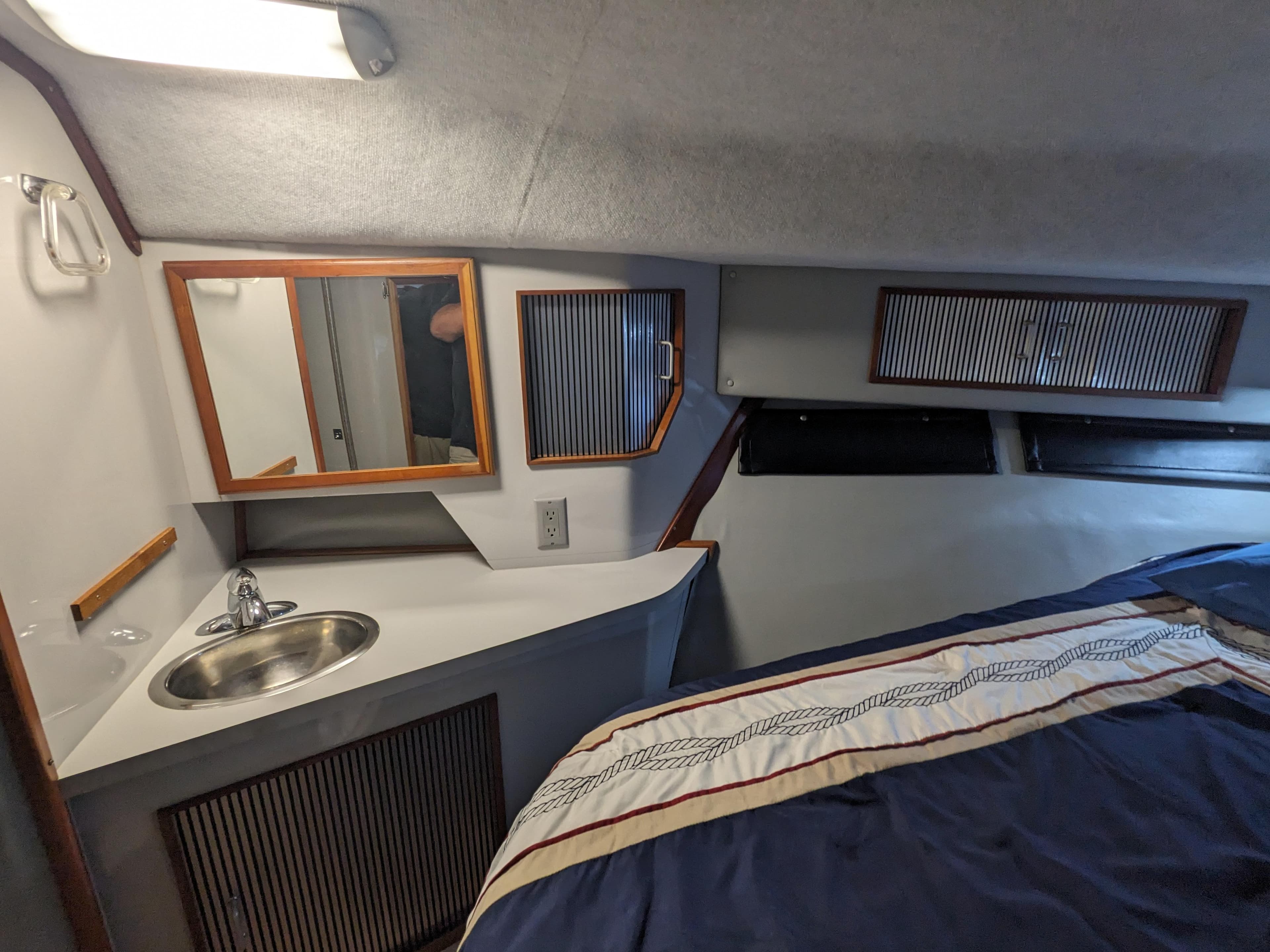 1988 Sea Ray 390 Express Cruiser cabin with sink, mirror, and bed.